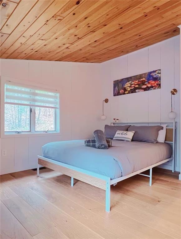 bedroom with wooden ceiling, light hardwood / wood-style flooring, and vaulted ceiling