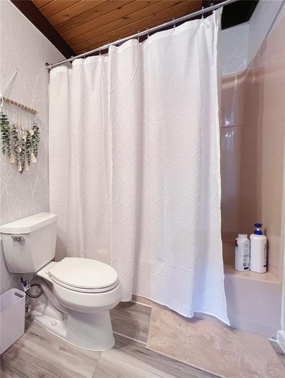 bathroom with toilet, wooden ceiling, shower / bathtub combination with curtain, and hardwood / wood-style flooring