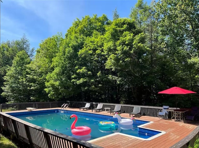 view of swimming pool featuring a diving board and a deck