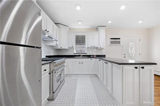 kitchen with a wall mounted AC, sink, white cabinets, and appliances with stainless steel finishes