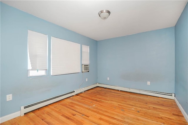 empty room with light wood-type flooring, a baseboard radiator, and baseboards