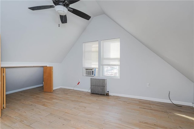 bonus room with baseboards, lofted ceiling, radiator heating unit, cooling unit, and light wood-style floors