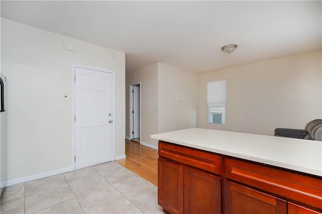 kitchen with baseboards, light countertops, and light tile patterned flooring