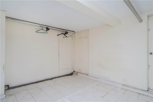 empty room featuring beam ceiling