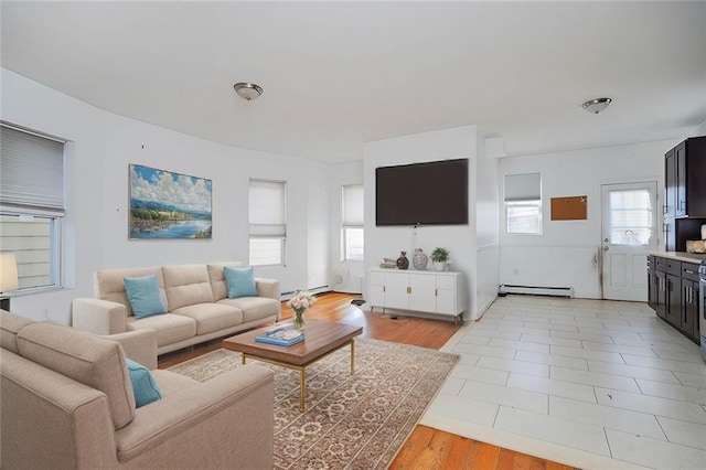 living area with light wood-style floors, a baseboard heating unit, and baseboard heating