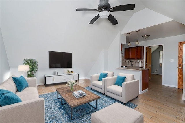 living room featuring high vaulted ceiling, light wood-style flooring, baseboards, and a ceiling fan