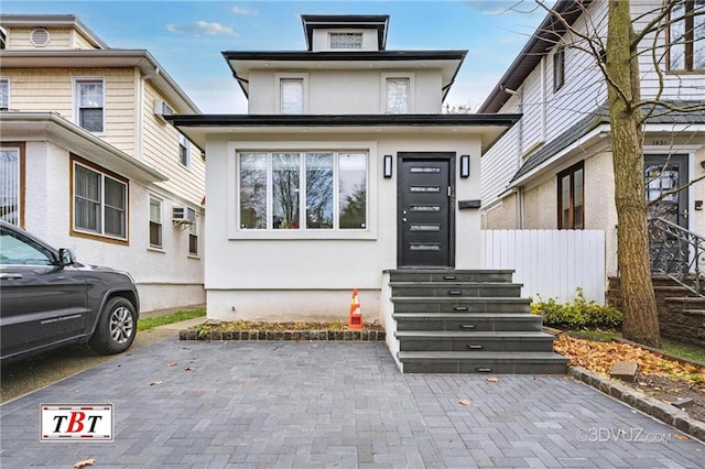 view of front facade featuring fence and stucco siding