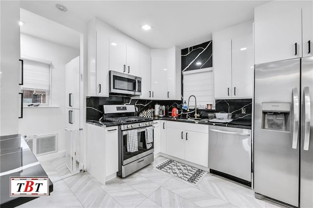 kitchen with white cabinetry, sink, decorative backsplash, and appliances with stainless steel finishes