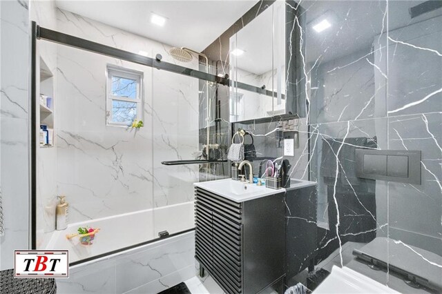 bathroom featuring a shower with door, vanity, and tile walls