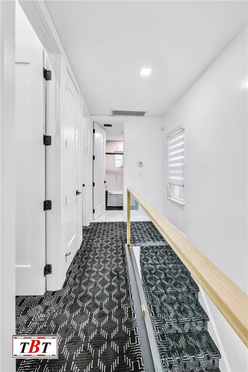 corridor featuring dark colored carpet