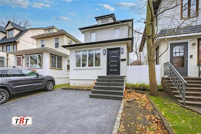 american foursquare style home featuring fence and stucco siding