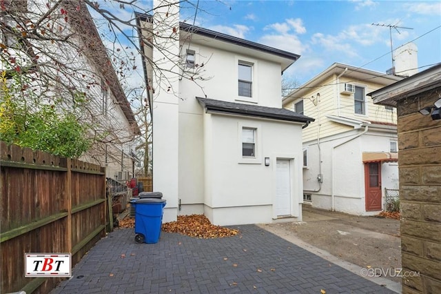 back of house with fence and stucco siding