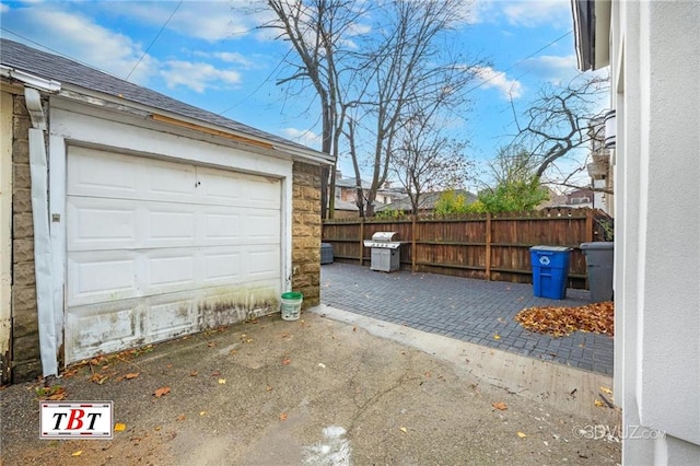 garage with driveway and fence