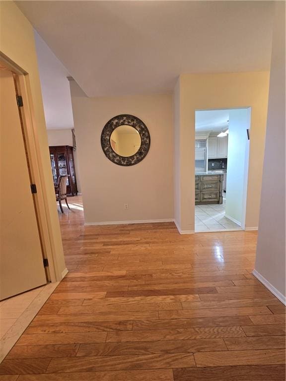 hallway featuring baseboards and light wood-style floors