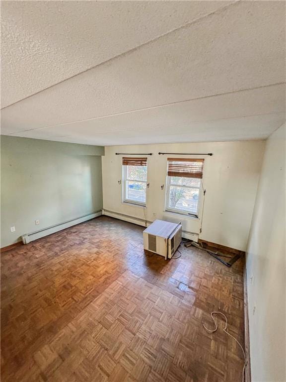 interior space featuring baseboard heating, parquet floors, and a textured ceiling