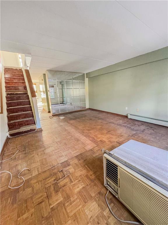 interior space featuring a baseboard heating unit, baseboards, and stairs