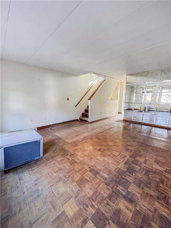 unfurnished living room featuring stairway