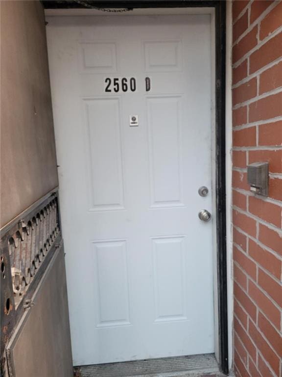 doorway to property with brick siding