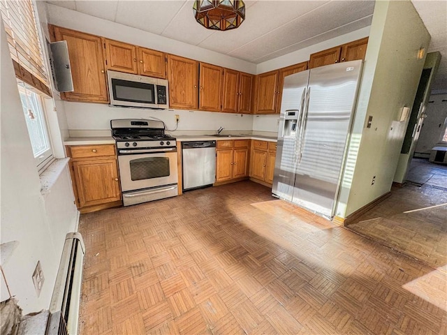 kitchen featuring light parquet flooring, a baseboard heating unit, sink, and stainless steel appliances