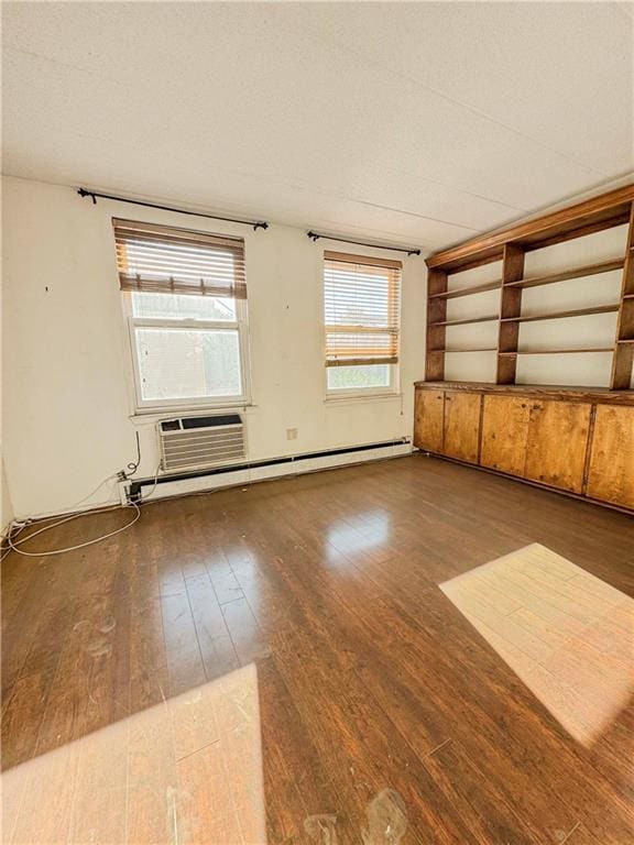 empty room with a textured ceiling, cooling unit, and dark wood-type flooring