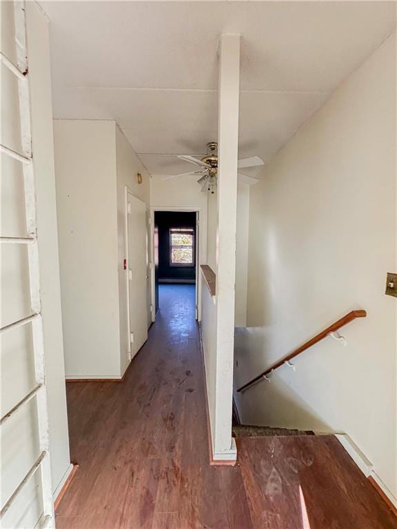 corridor featuring dark wood finished floors and an upstairs landing