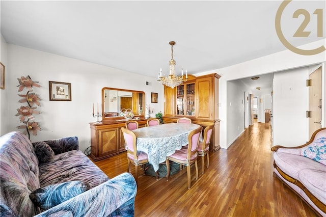 dining space with a notable chandelier and dark hardwood / wood-style flooring