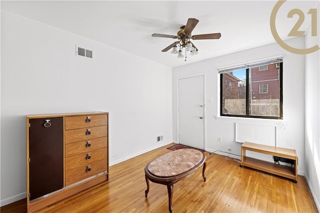 living area with hardwood / wood-style floors and ceiling fan