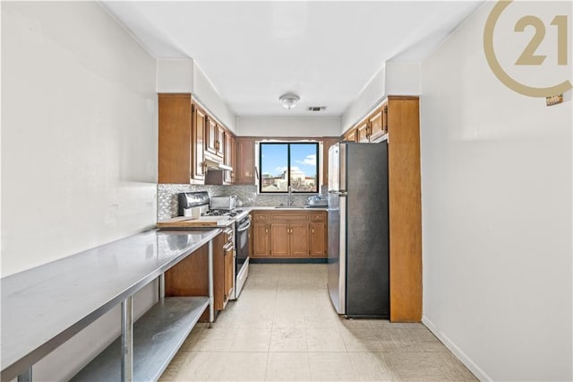 kitchen with appliances with stainless steel finishes, backsplash, and sink