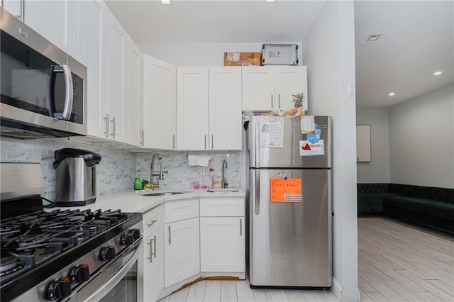 kitchen featuring stainless steel appliances, white cabinets, and light countertops