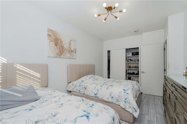 bedroom featuring wood finish floors and a notable chandelier