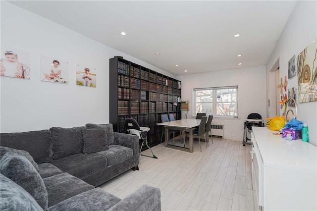 living area with light wood-type flooring, radiator, and recessed lighting