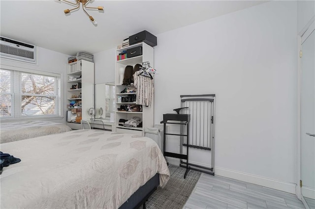 bedroom with baseboards and a wall mounted AC