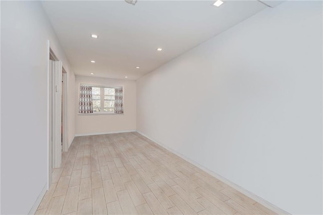 empty room featuring baseboards, recessed lighting, and light wood-style floors