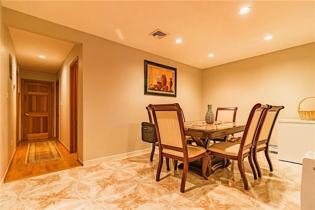 dining area with light tile patterned flooring and a baseboard radiator