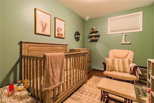 bedroom featuring a crib and a baseboard radiator