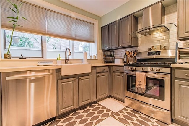 kitchen with sink, wall chimney exhaust hood, decorative backsplash, light tile patterned flooring, and stainless steel appliances