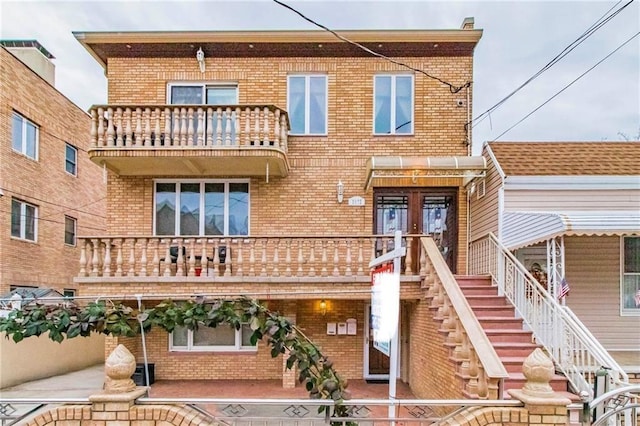 2572 W 16th St, Brooklyn, NY 11214 - view of front facade featuring brick siding, a balcony, and stairway