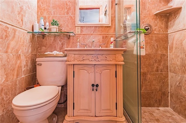 bathroom with vanity, toilet, tiled shower, and tile walls