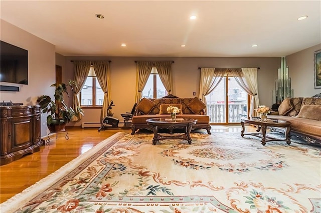 living room with baseboard heating and light wood-type flooring