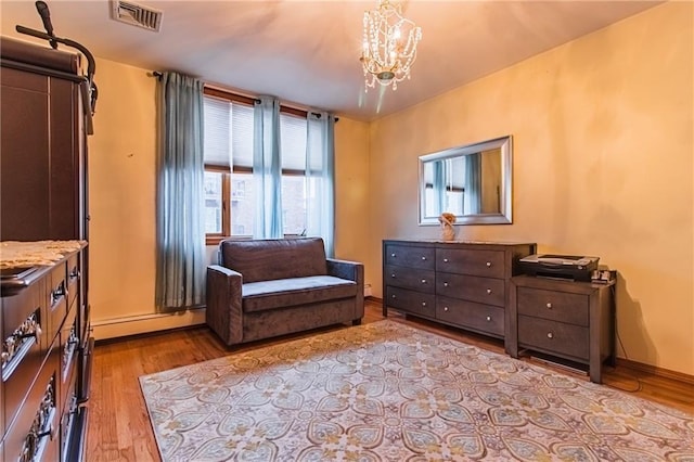 sitting room featuring light hardwood / wood-style flooring, an inviting chandelier, and baseboard heating