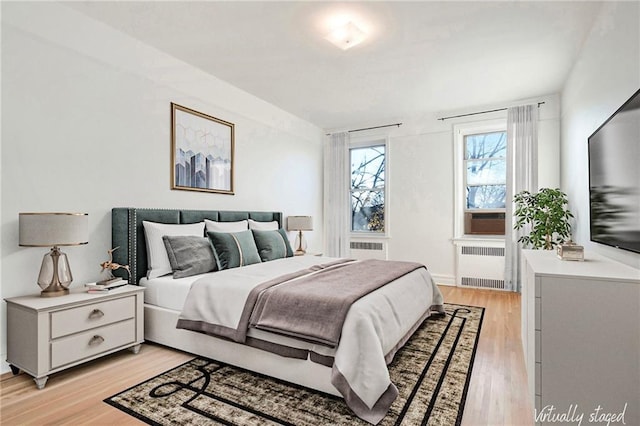 bedroom featuring light wood-type flooring and radiator heating unit