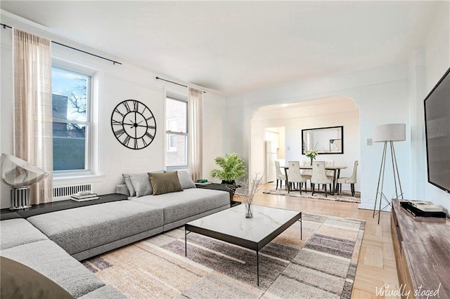 living room featuring radiator and light parquet floors