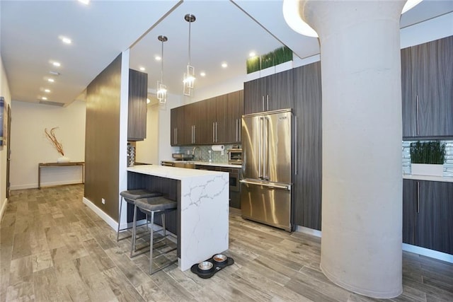 80 Bay St Unit 4A, Staten Island, NY 10301 - kitchen featuring high end refrigerator, a breakfast bar area, light wood-style floors, a peninsula, and backsplash