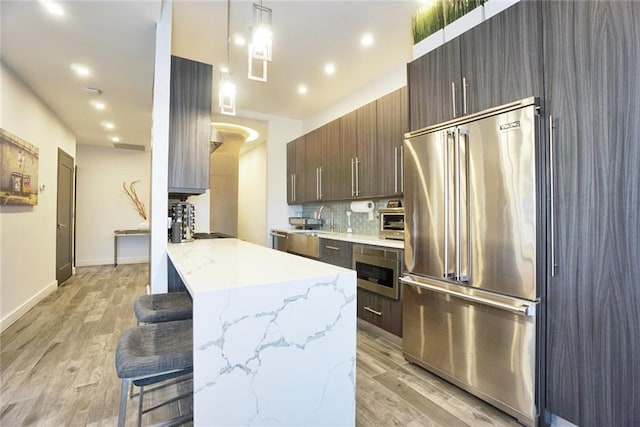 80 Bay St Unit 4A, Staten Island, NY 10301 - kitchen with high end fridge, a kitchen bar, light wood finished floors, modern cabinets, and recessed lighting