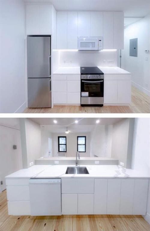 kitchen featuring sink, white cabinets, stainless steel appliances, and light hardwood / wood-style floors