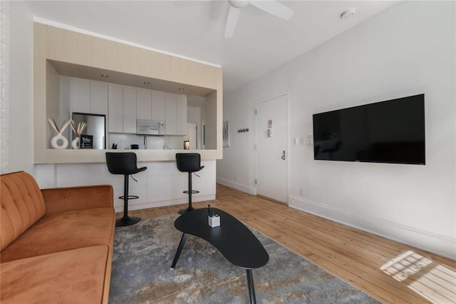 living room featuring hardwood / wood-style floors and ceiling fan