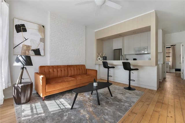 living room with wood-type flooring and ceiling fan