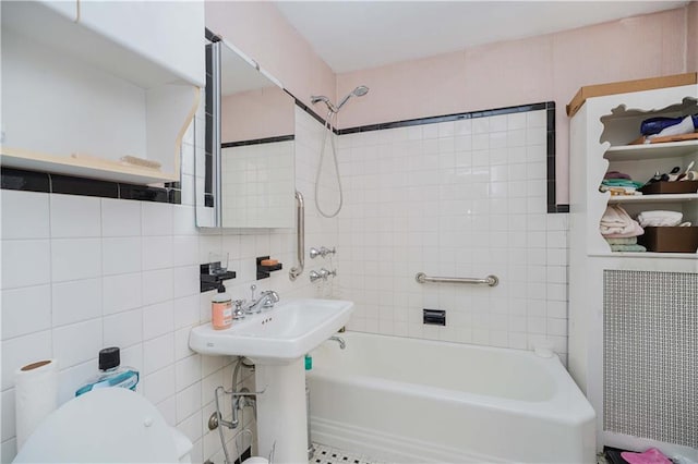 bathroom with tasteful backsplash, tiled shower / bath combo, tile walls, and toilet