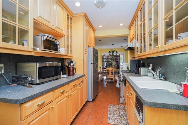 kitchen featuring tile patterned floors, backsplash, sink, and appliances with stainless steel finishes