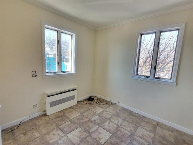 spare room featuring crown molding, a healthy amount of sunlight, and heating unit